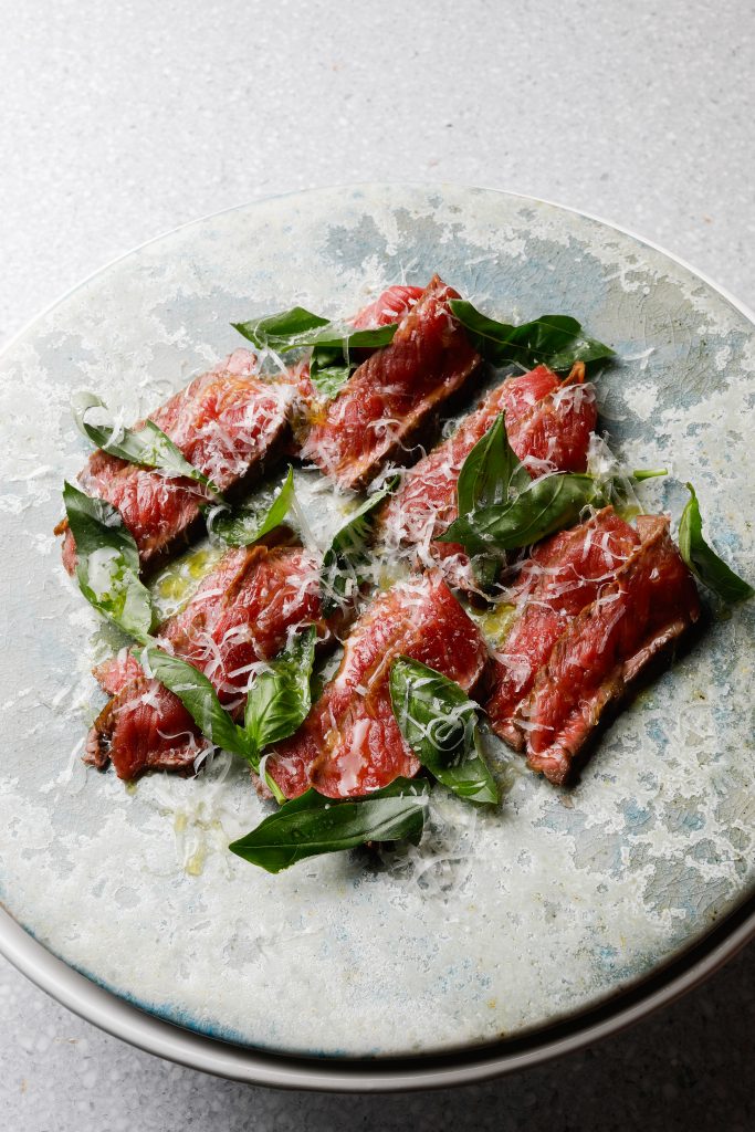 Opskrift på tagliata med møre skiver af oksekød, friske basilikumblade, friskrevet parmesan og koldpresset olivenolie. Enkel italiensk servering til 4 personer.
