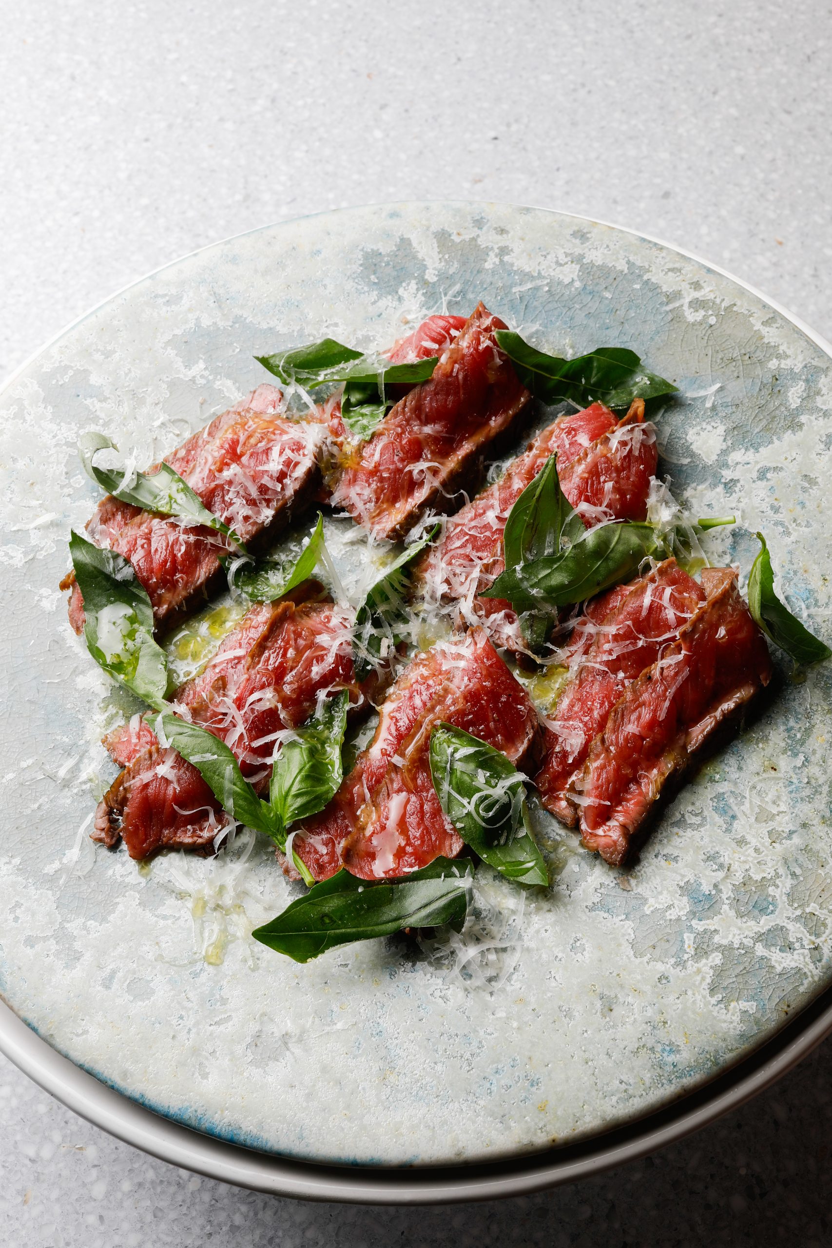 Opskrift på tagliata med møre skiver af oksekød, friske basilikumblade, friskrevet parmesan og koldpresset olivenolie. Enkel italiensk servering til 4 personer.